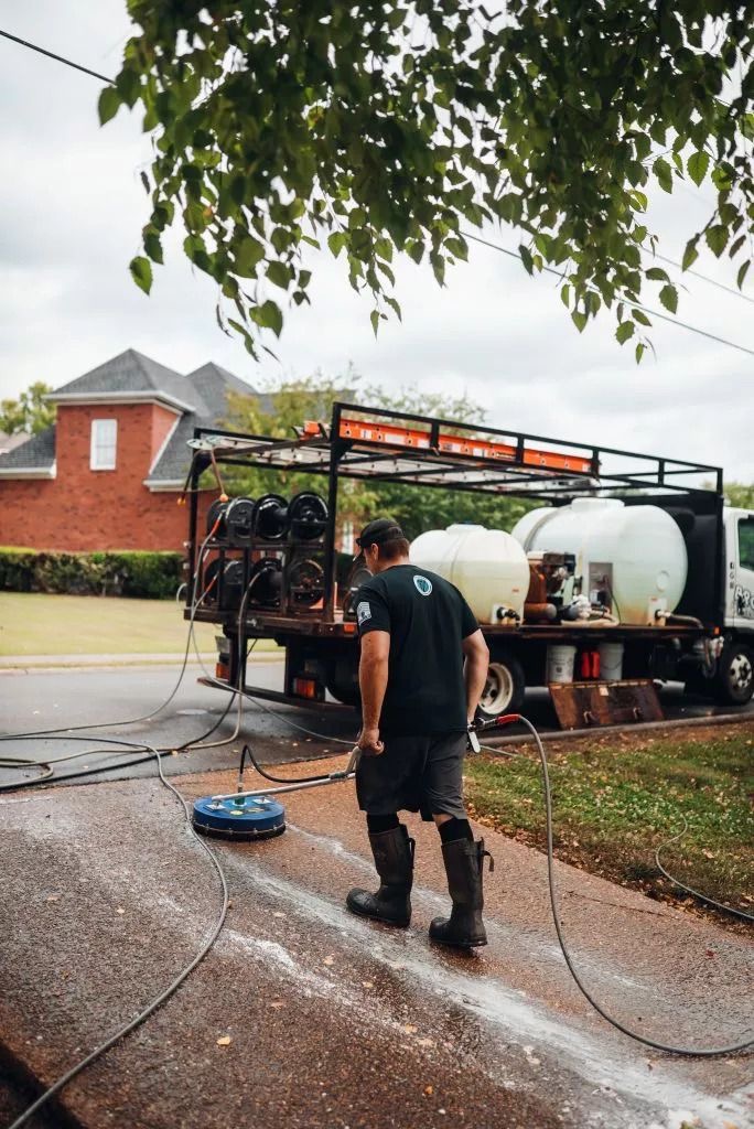 Pressure washing technician cleaning a driveway